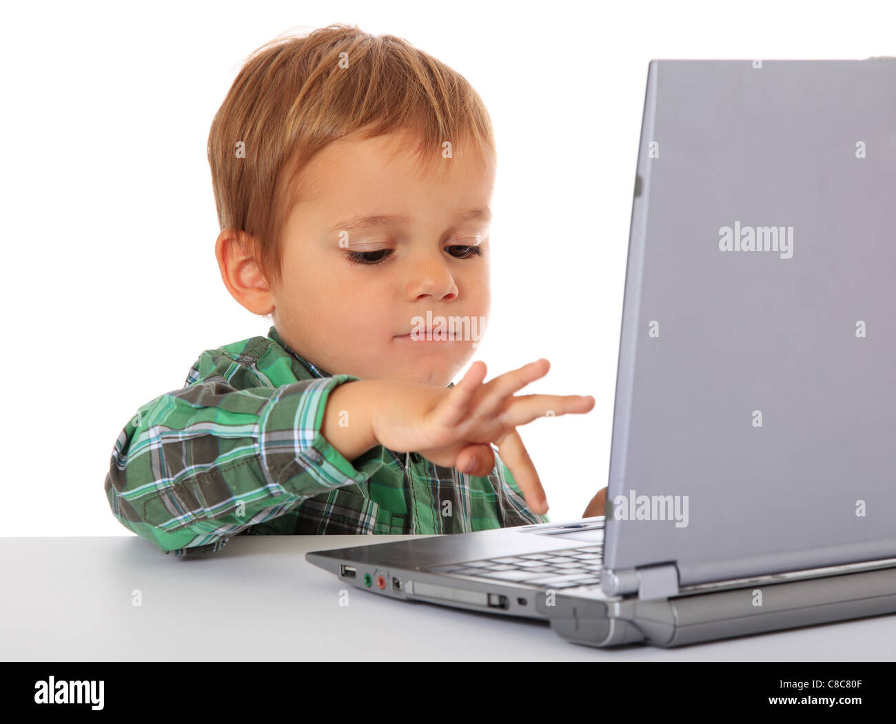 Cute caucasian boy using laptop. All on white background. Stock Photo
