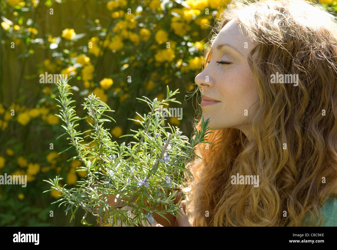 Woman smelling herbs in backyard Stock Photo Alamy