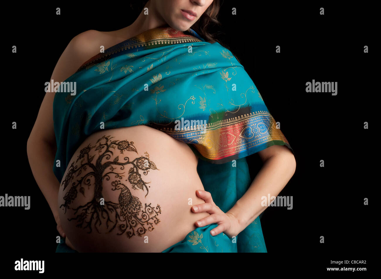 A color photo of a henna "tree of life" design on a woman's pregnant