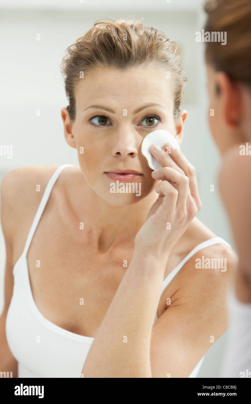 Woman cleansing her face in bathroom Stock Photo Alamy
