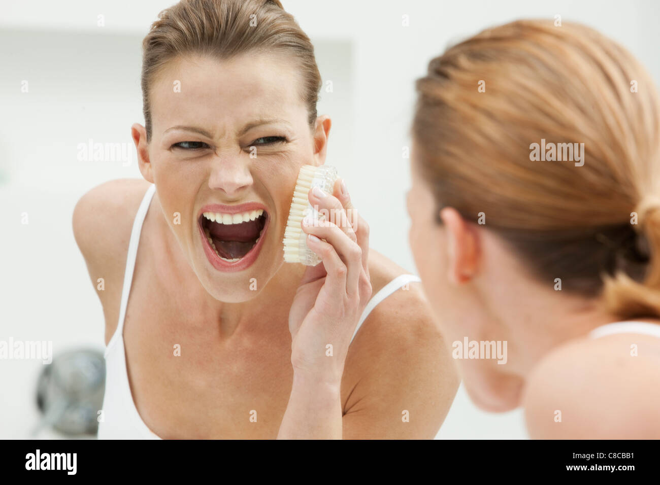 Woman scrubbing her face Stock Photo