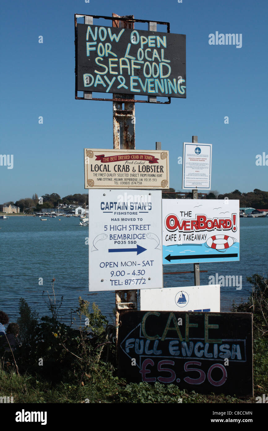 Signposts advertising seafood at various cafes and restaurants at