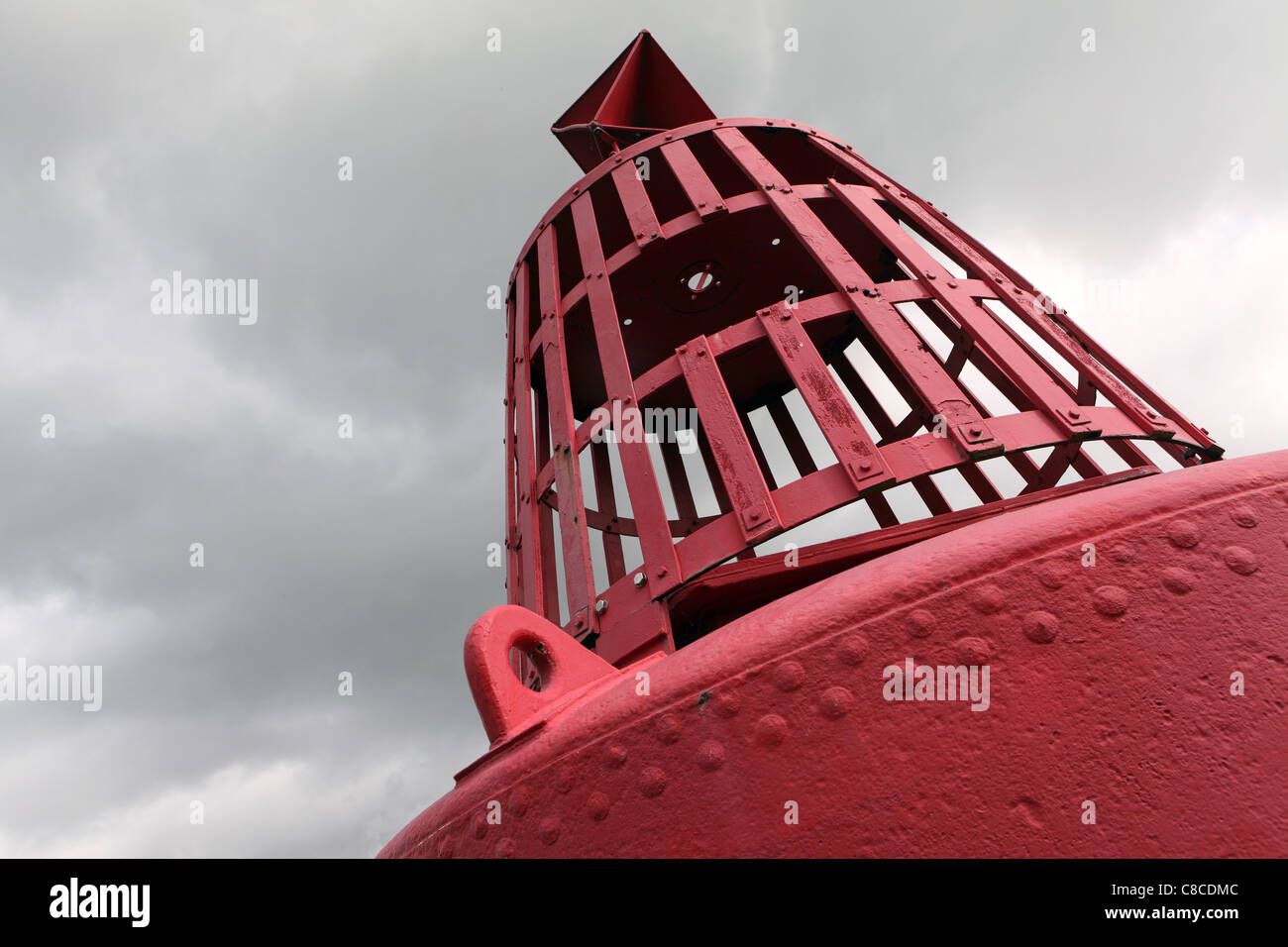 Port hand buoy (Red), marks the shipping channel, detail with gray sky behind, Harwich, Suffolk, UK Stock Photo