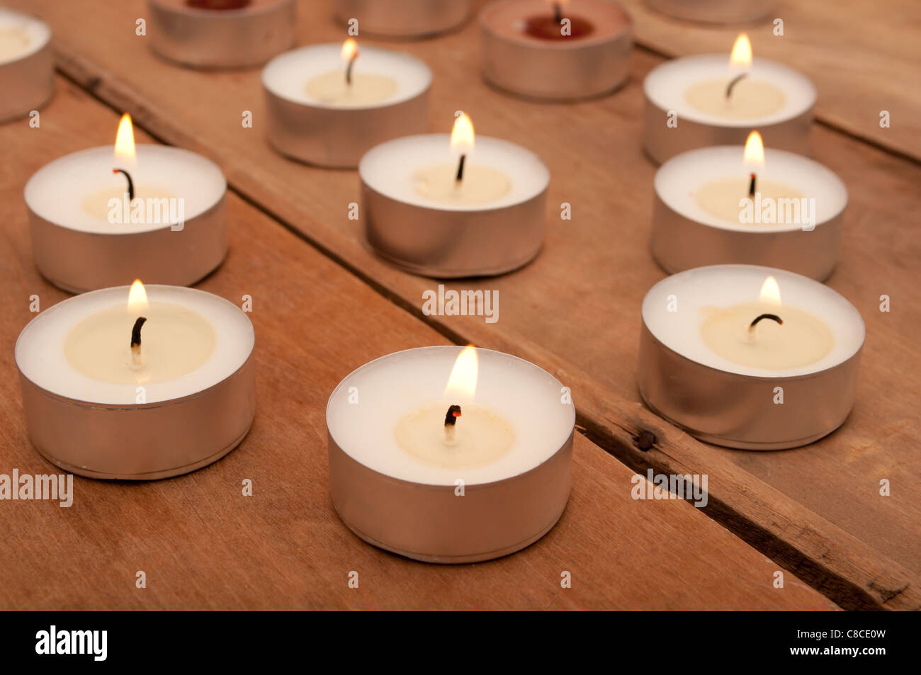 Many Burning Candles on Aged Wooden Table Stock Photo - Alamy