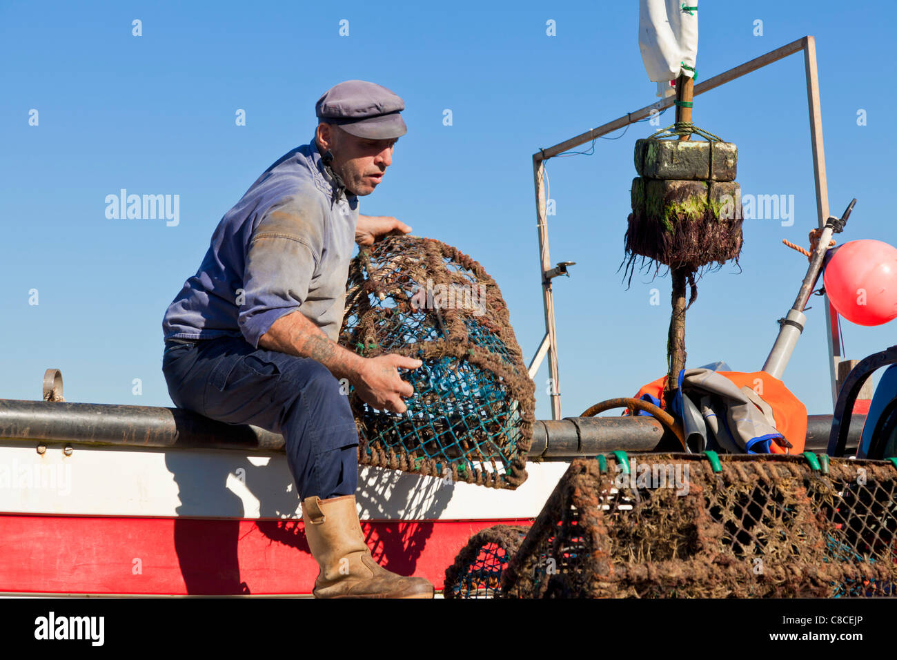 Fisherman taking crab pots off his fishing boat Cromer Norfolk East