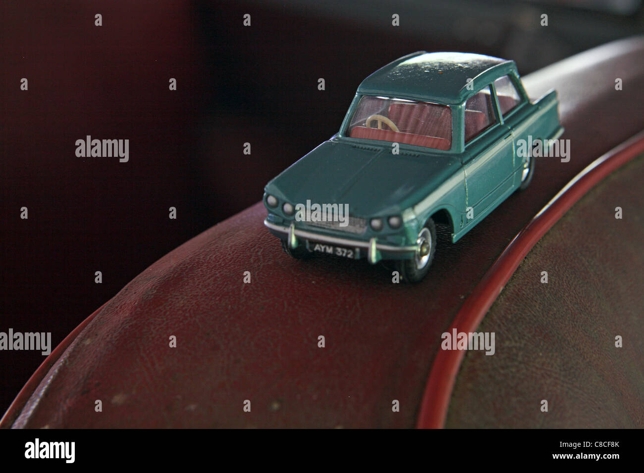 Vintage Dinky toy car, Triumph Herald, perched on top of back of old car seat Stock Photo