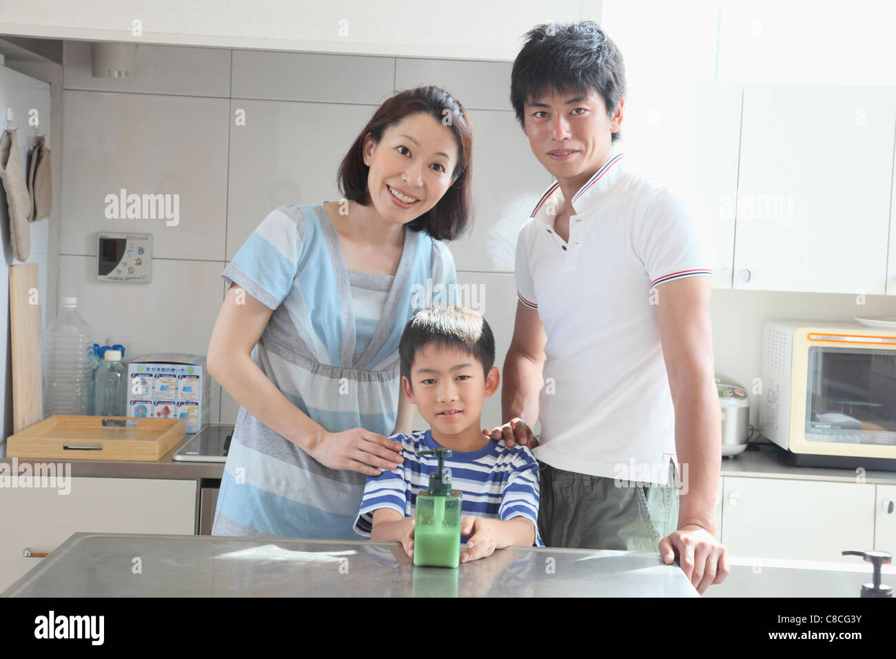 Family standing and smiling at kitchen Stock Photo