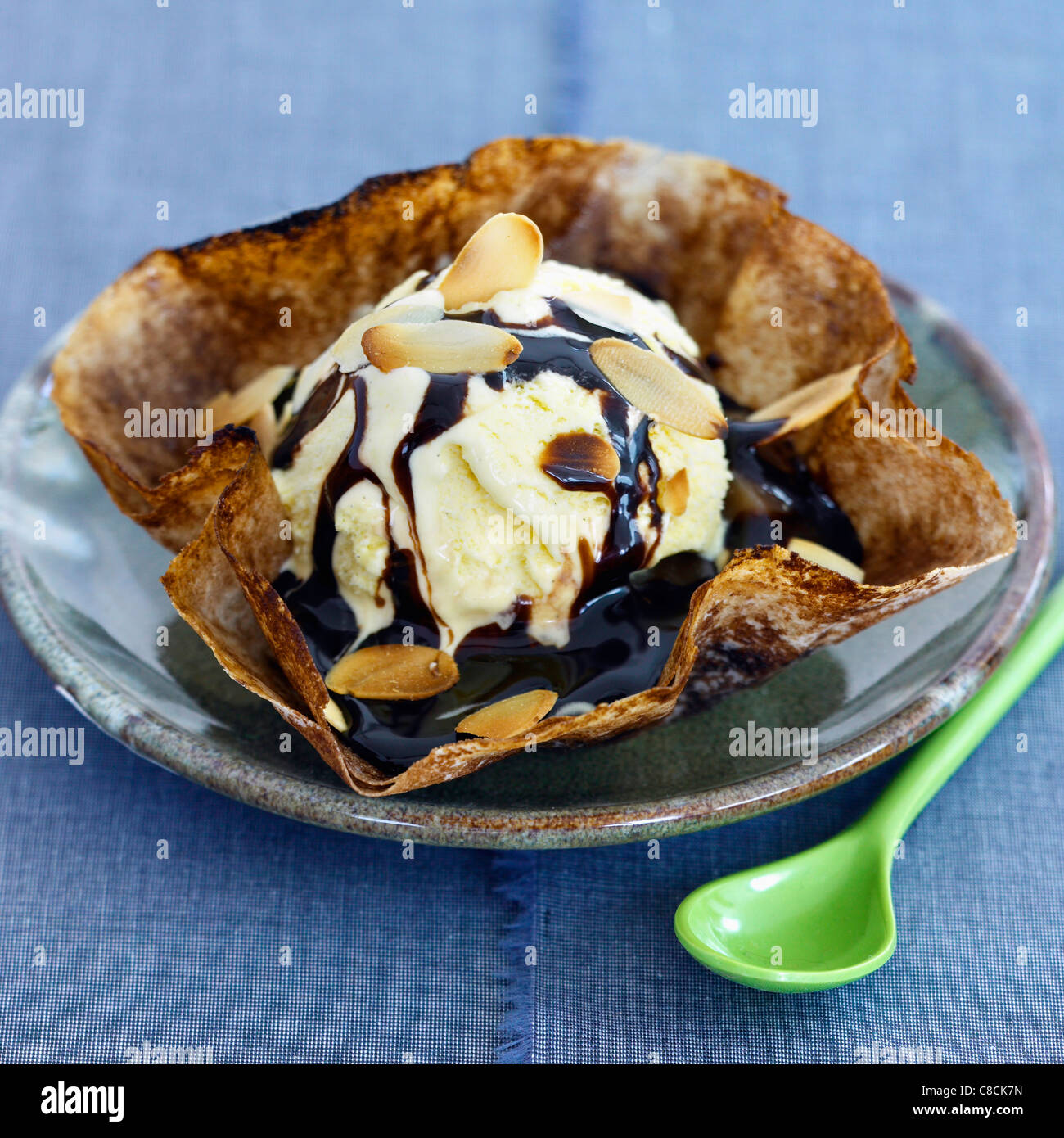Flower-shaped pancake filled with vanilla ice cream,melted chocolate and sliced almonds Stock Photo