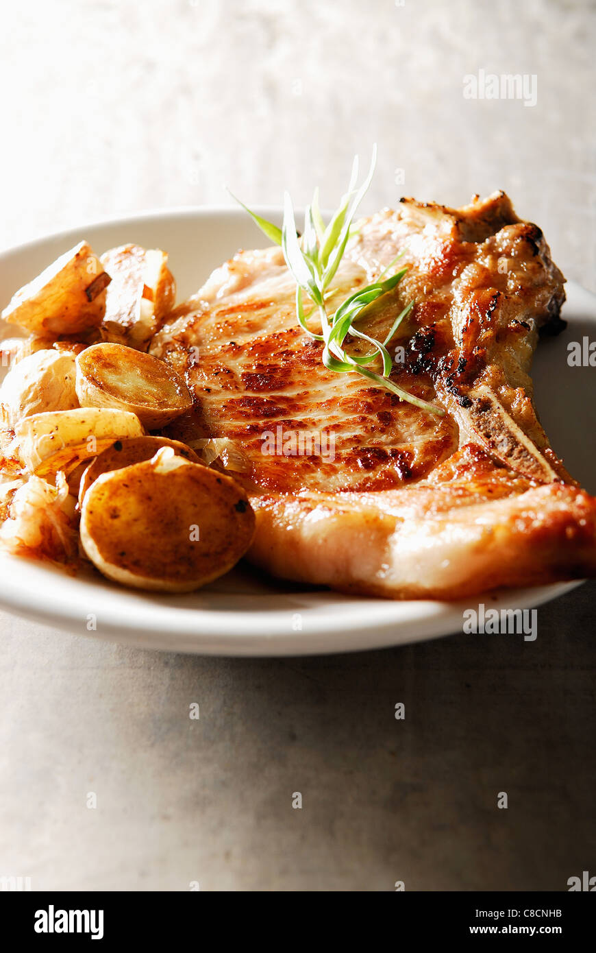 Panfried veal chop with potatoes and tarragon cream sauce Stock Photo
