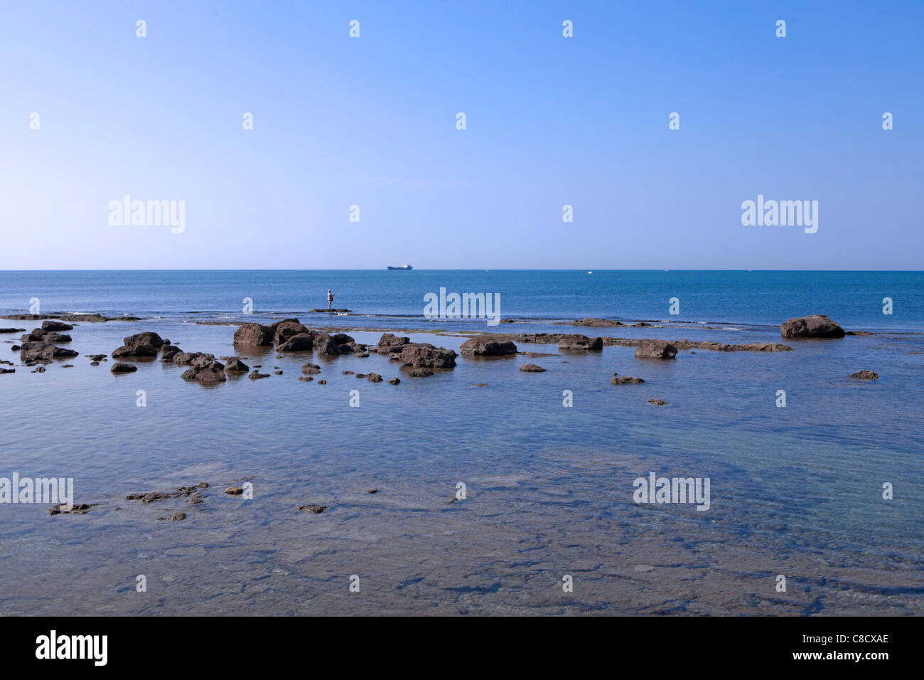 a fisherman on the rocks in the Mediterranean off Leghorn Stock Photo