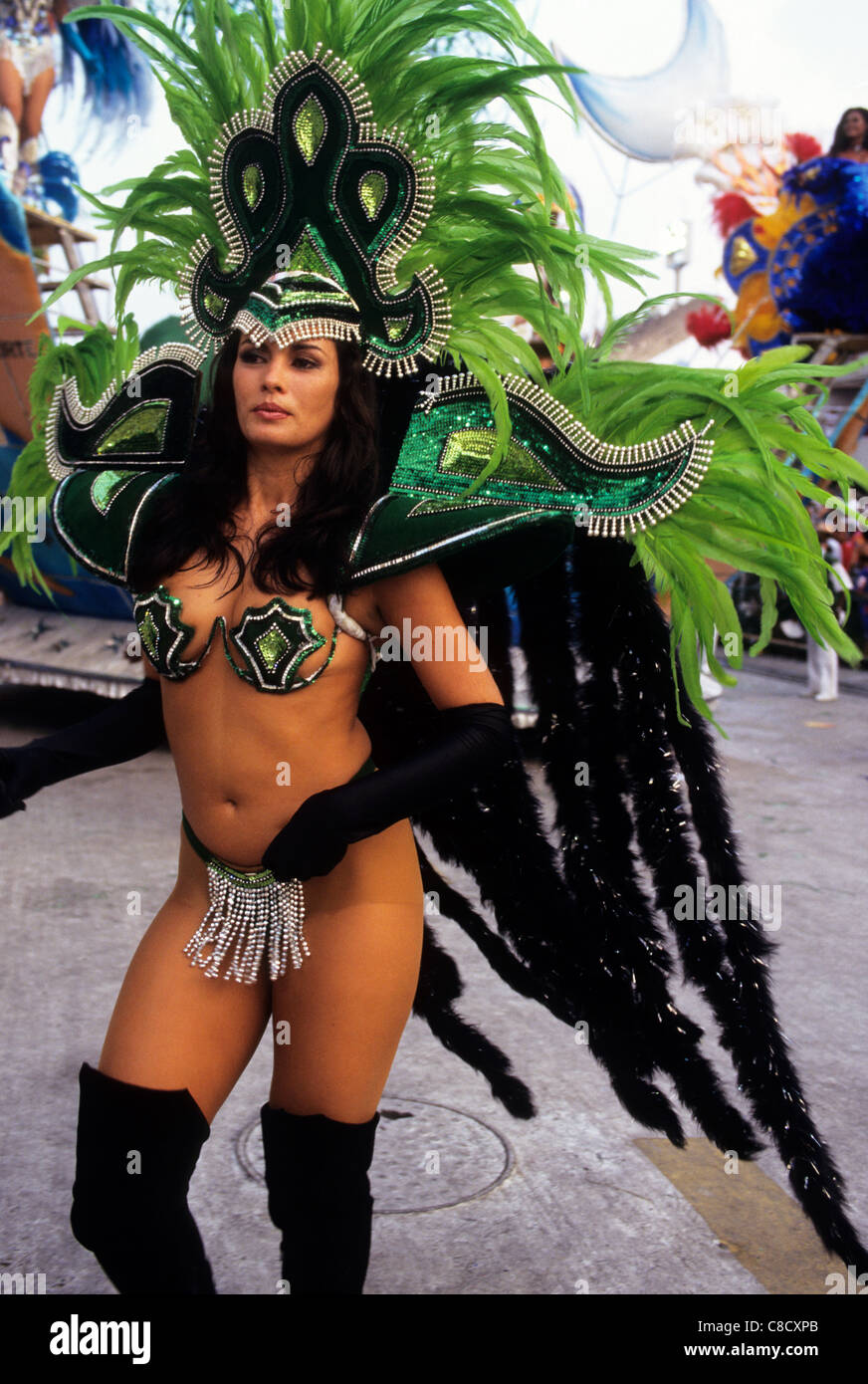 Rio de Janeiro, Brazil. Carnival samba school; girl in skimpy dark and light green bikini costume with large feather headdress. Stock Photo