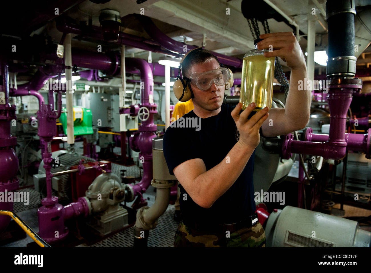 Checking a fuel sample for clarity during fuel purification aboard the aircraft carrier USS John C. Stennis (CVN 74) Stock Photo