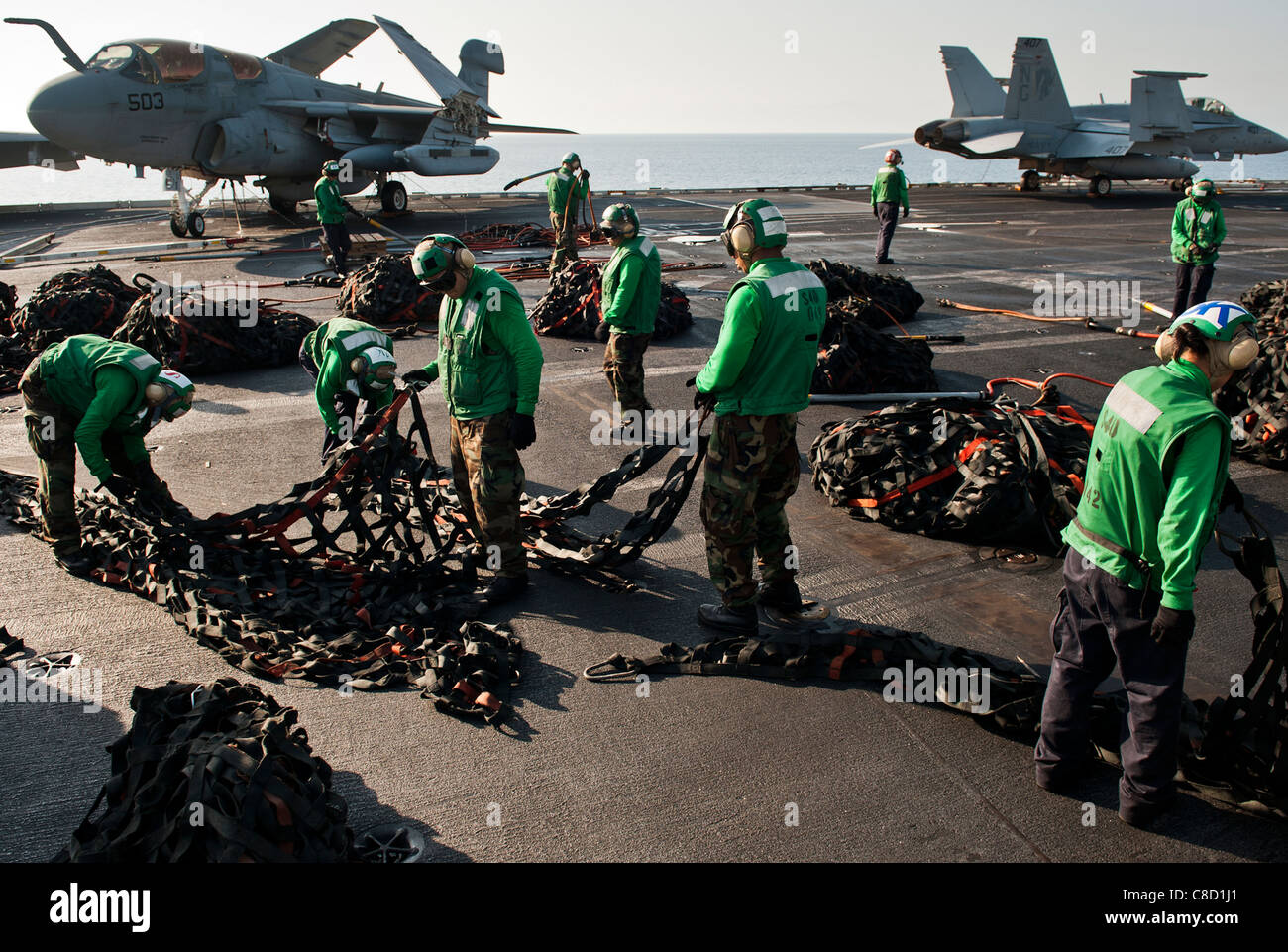 Logistics specialists bundle cargo nets during a vertical replenishment aboard the Nimitzclass