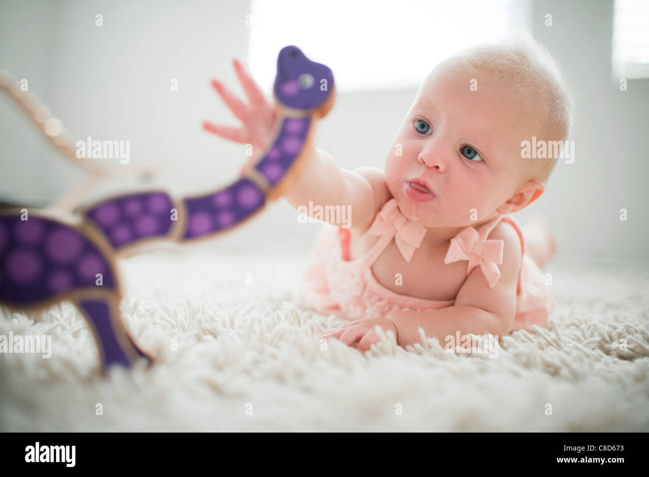 Baby Girl Playing with Wooden Toy Stock Photo
