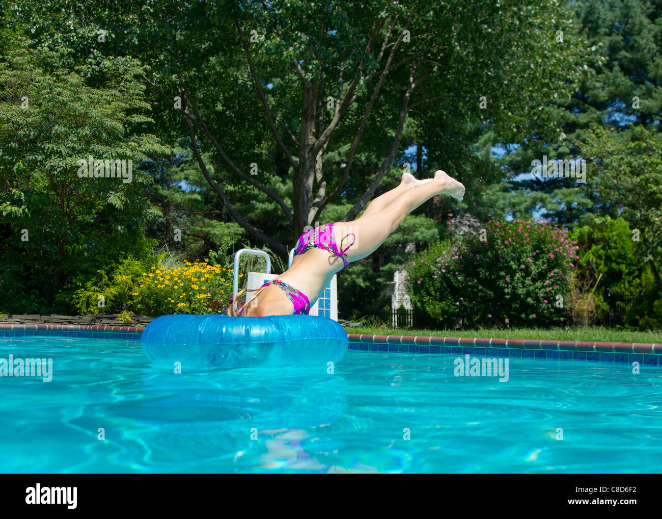 Young girl diving into a swimming pool Stock Photo