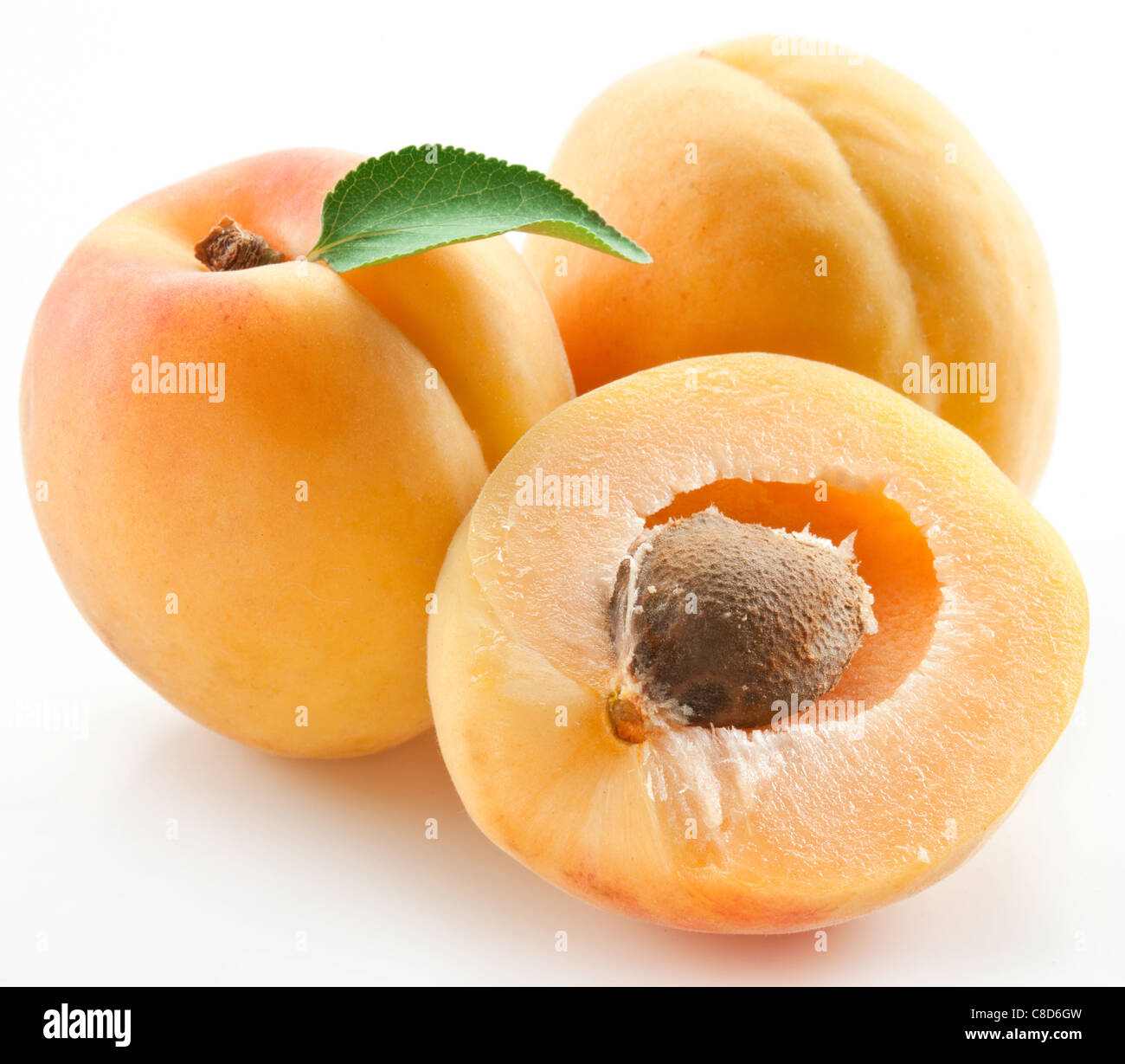 Apricots with leaves on a white background Stock Photo - Alamy