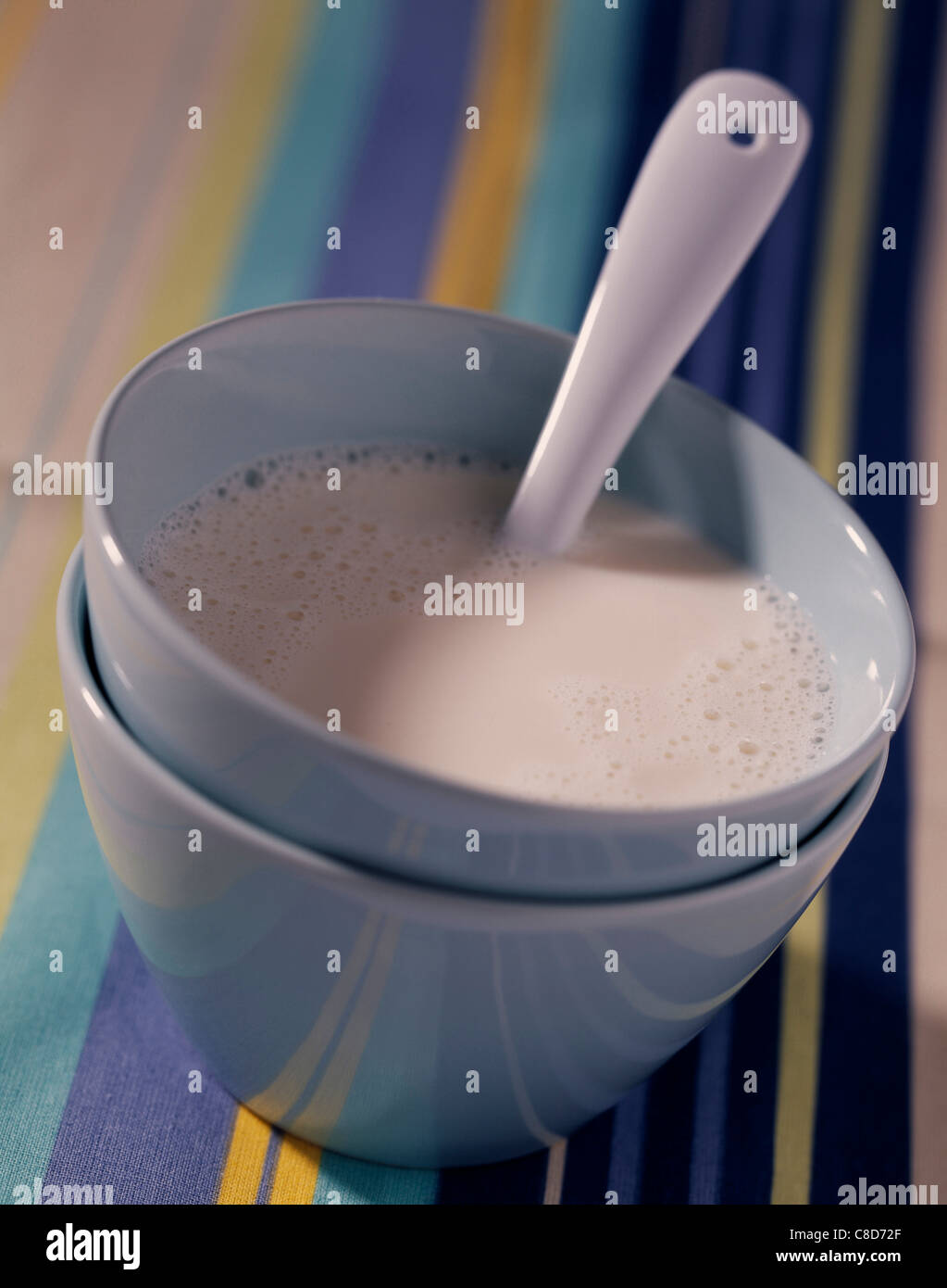Bowl of milk with spoon Stock Photo
