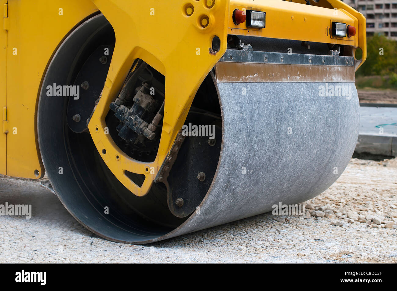 Yellow roller tamping gravel. Very close up Stock Photo Alamy