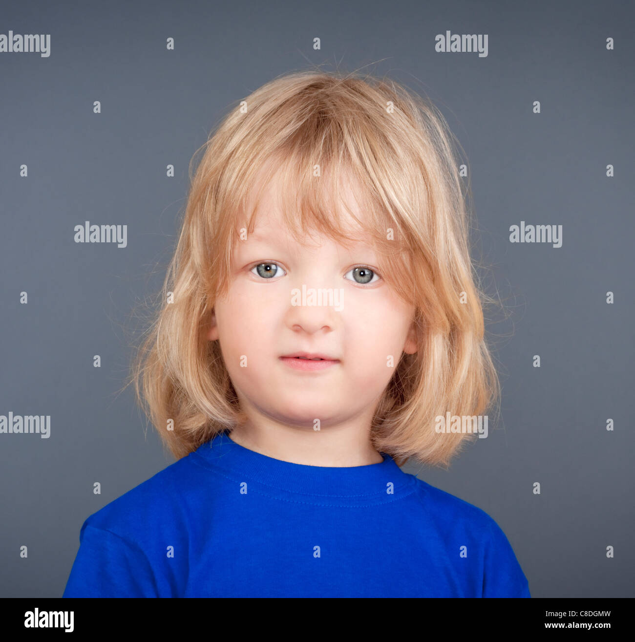 studio portrait of a boy with long blond hair - isolated on gray Stock Photo