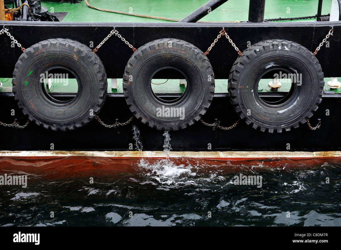Close up of truck tyres used as fenders on the side of a tugboat in