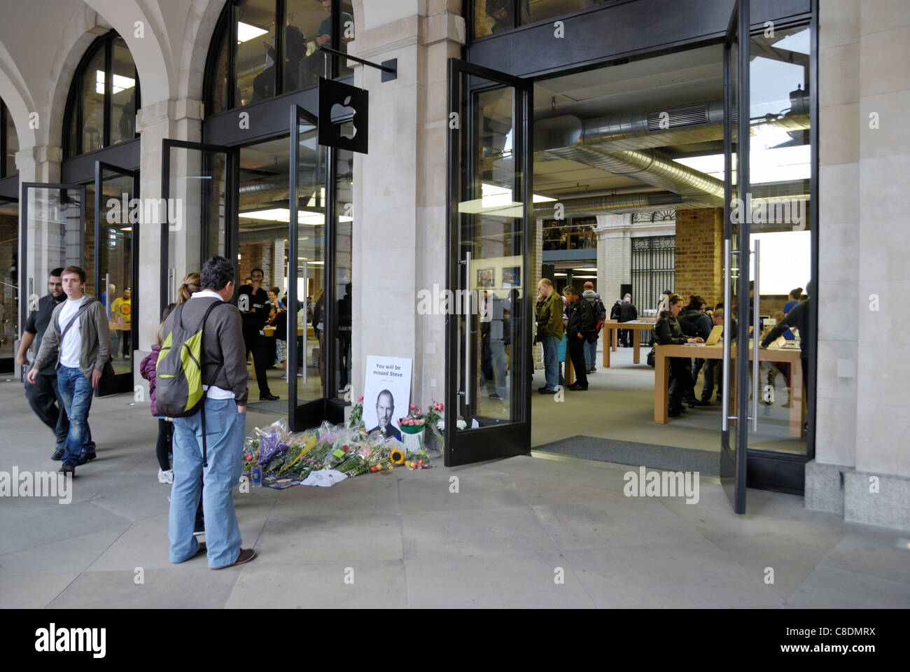 People paying their respects at a makeshift shrine to Steve Jobs outside the Apple Store in London’s Covent Garden. Stock Photo