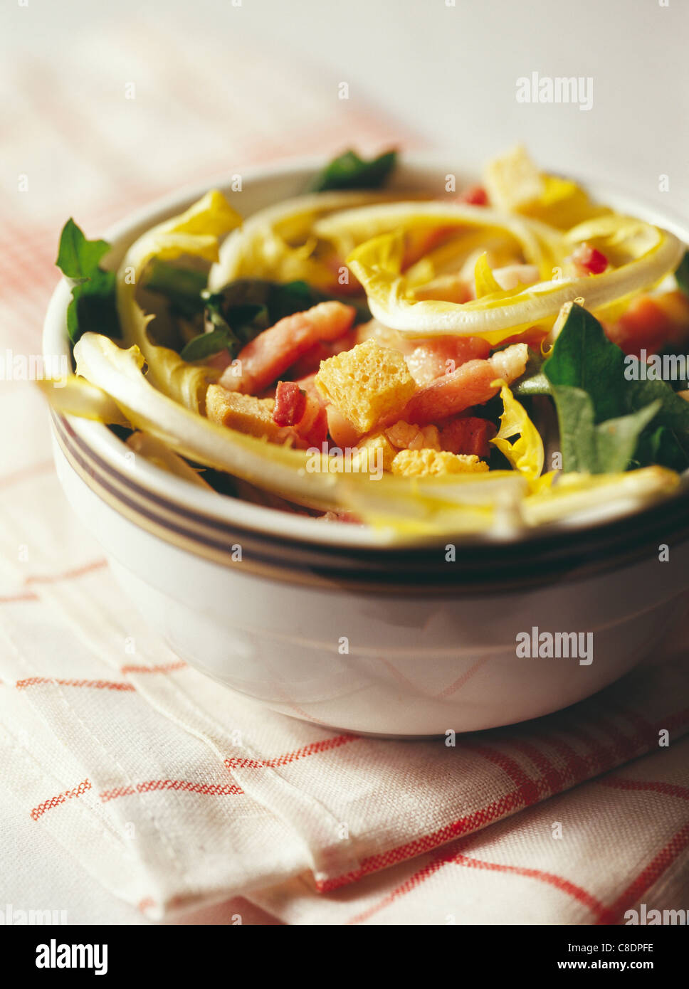 Curly endive,dandelion and diced bacon salad Stock Photo