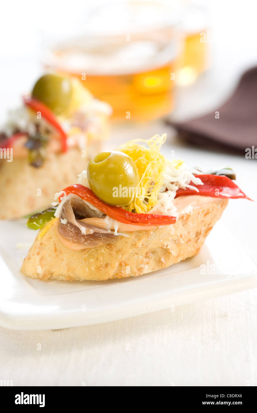 Anchovy,egg ,red pepper and green olive on a bite-size slice of bread Stock Photo