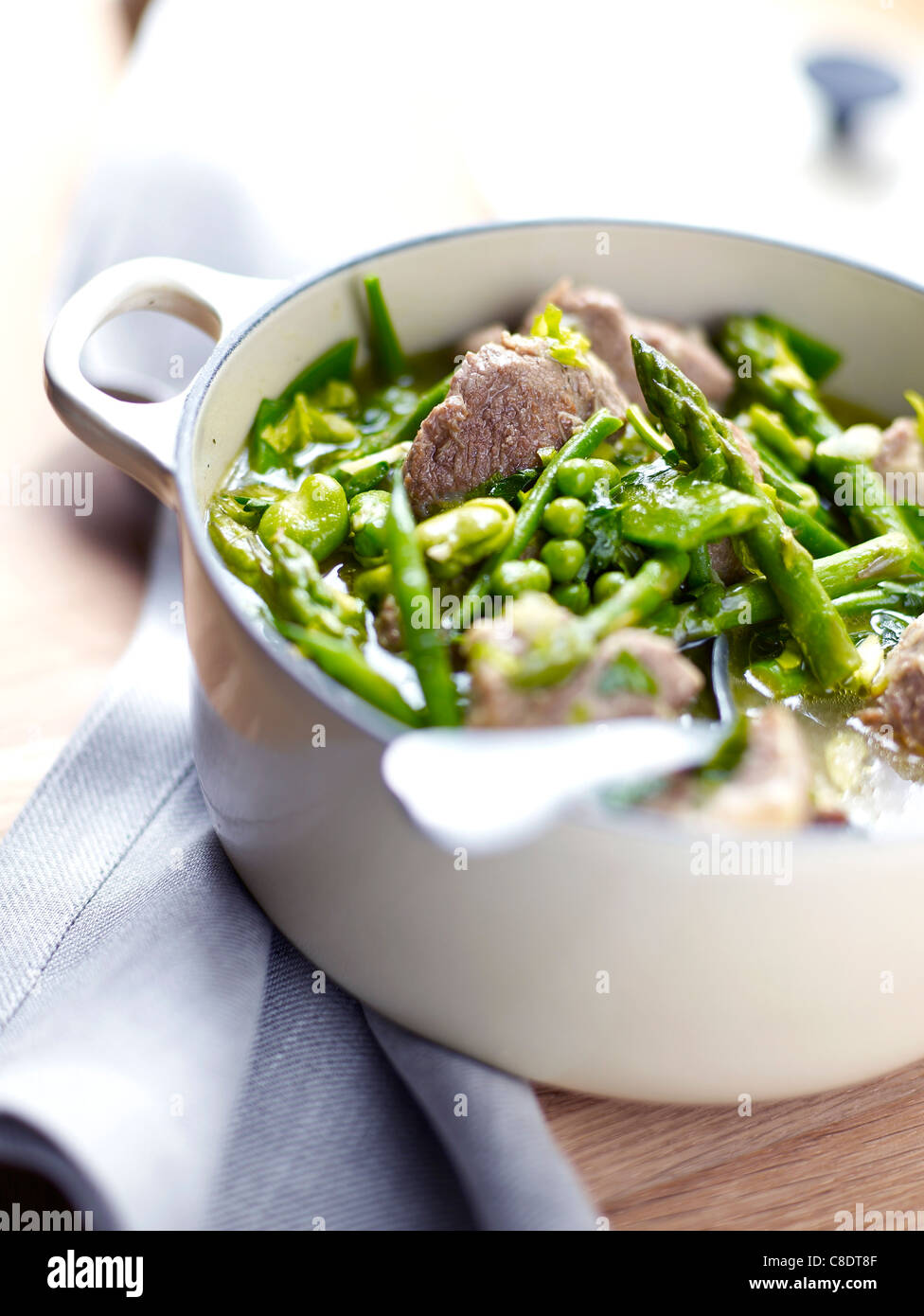 Casserole dish of lamb and green vegetables Stock Photo