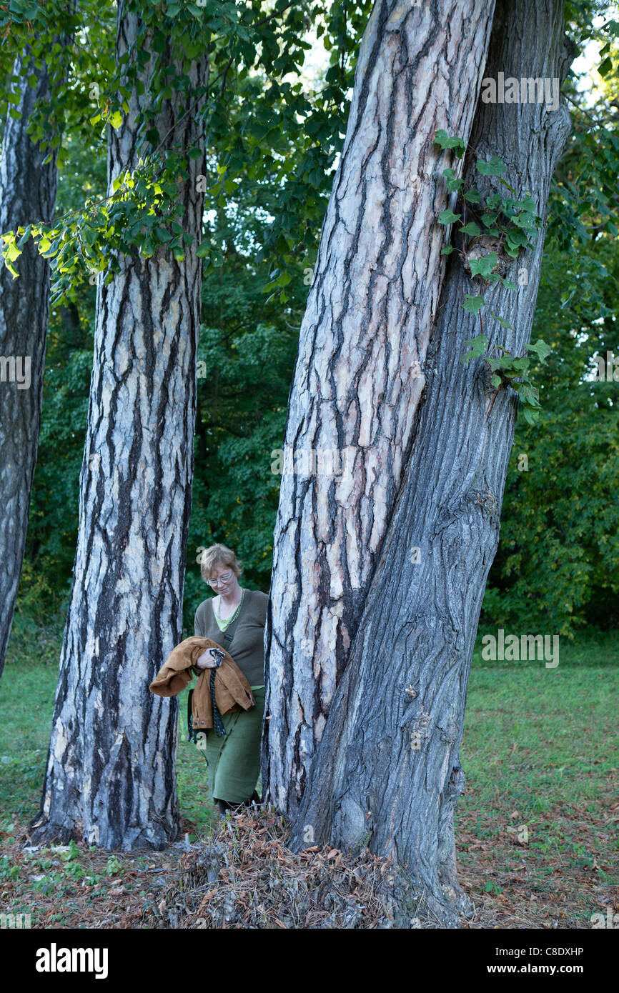 woman looking at trees that have grown into each other Stock Photo