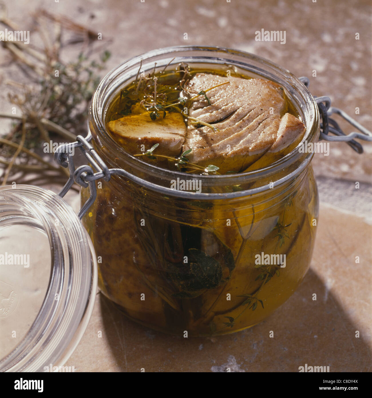 Tuna marinated in olive oil with herbs Stock Photo