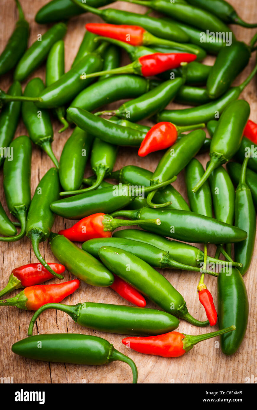 A bunch of red and green hot peppers on a wooden background Stock Photo ...