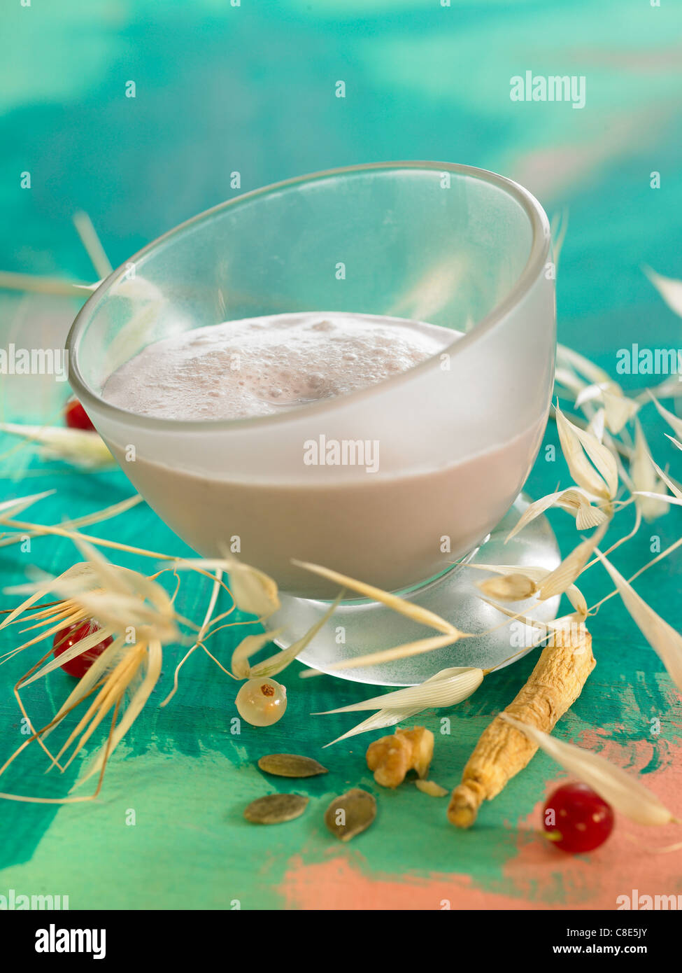 Oat milk with redcurrant cordial and squash seeds Stock Photo