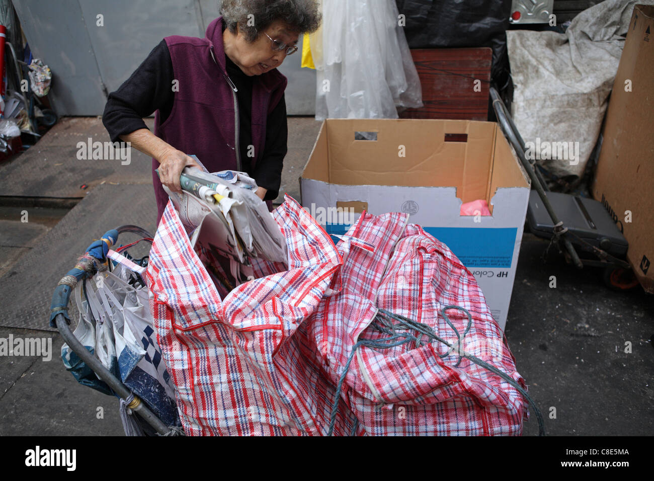 elderly woman taking paper & card to sell at a recycling depot in Hong Kong China, Asia Stock Photo