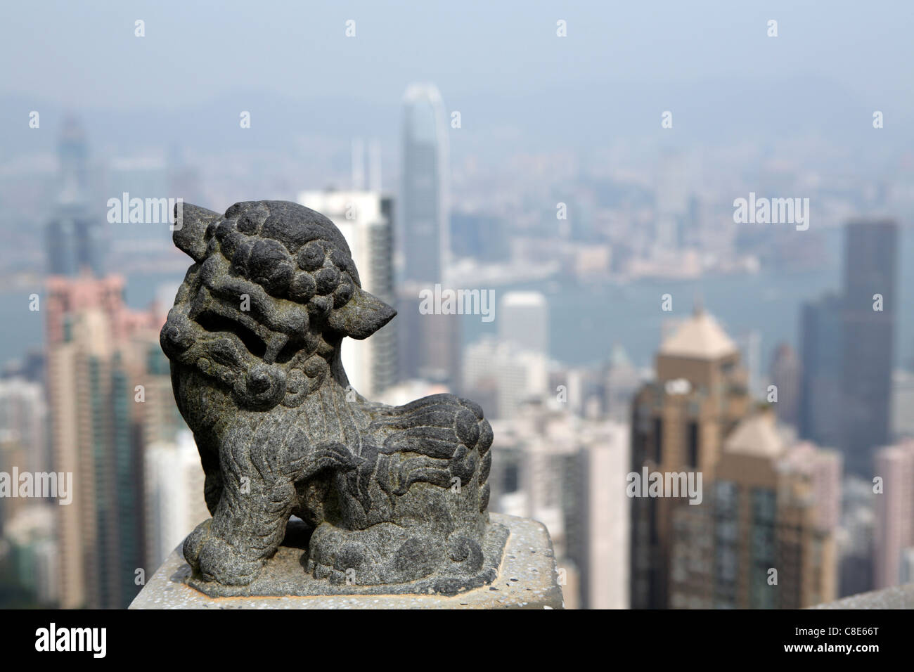 stone statue of Chinese dragon at The Peak, with view behind, overlooking Victoria Harbour & skyscrapers Hong Kong, China Stock Photo