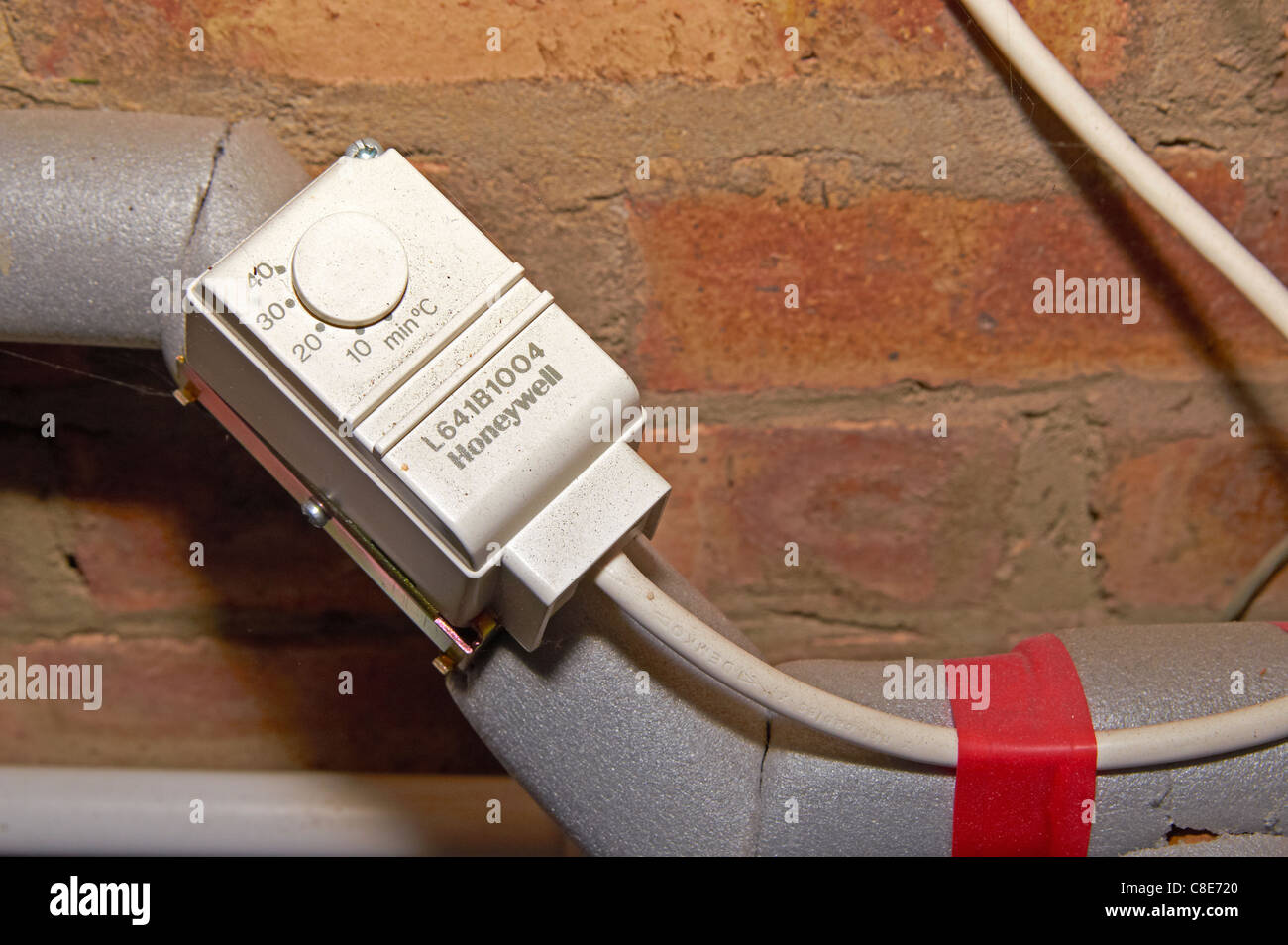 Frost thermostat on pipework in an outside boiler house. The thermostat