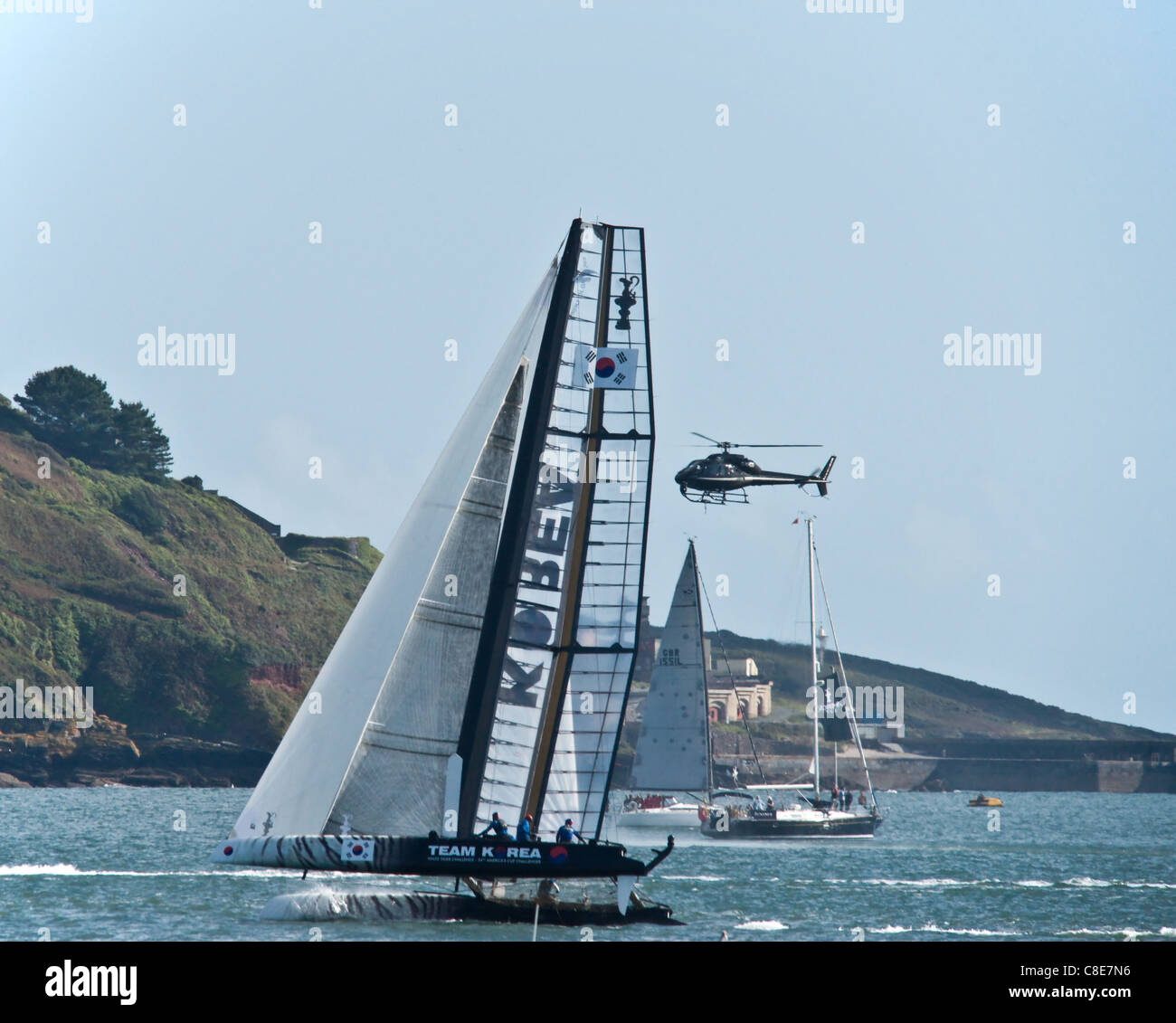 Catamaran in the Americas Cup with a helicopter to one side filing the event. Stock Photo