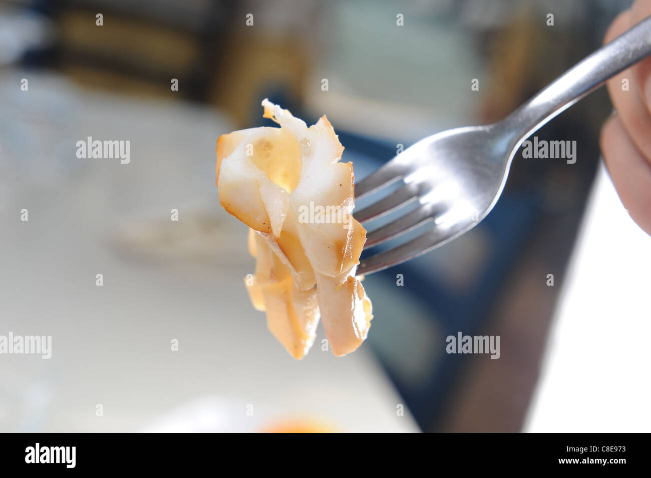 squid forkful in a restaurant Stock Photo Alamy