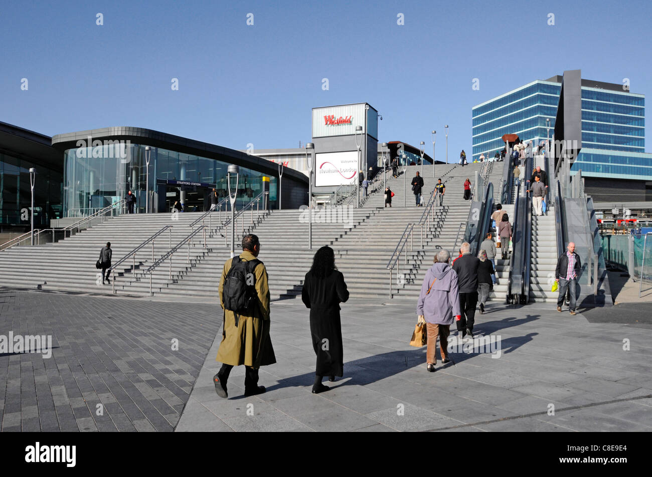 Multicultural people using steps & escalators to new entrance to Stratford London train station & the Westfield shopping centre & office building UK Stock Photo