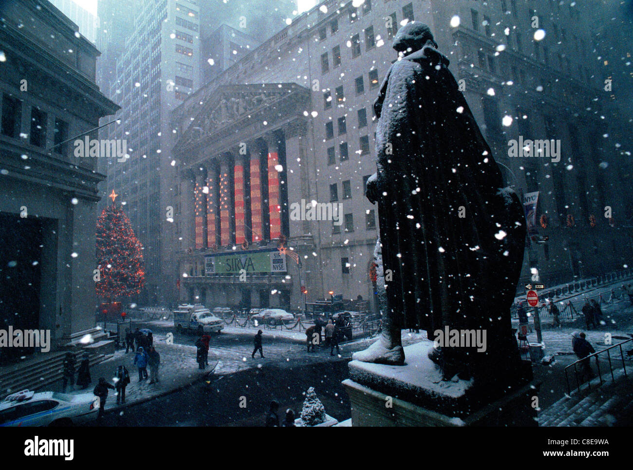 The statue of George Washington at 26 Federal Hall stands over the New York Stock Exchange in the snow Stock Photo