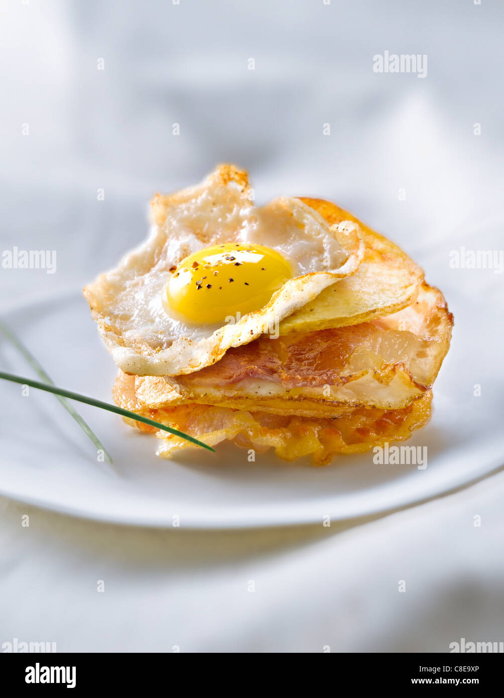Potato crisps,pancetta and fried quail's egg Millefeuille Stock Photo