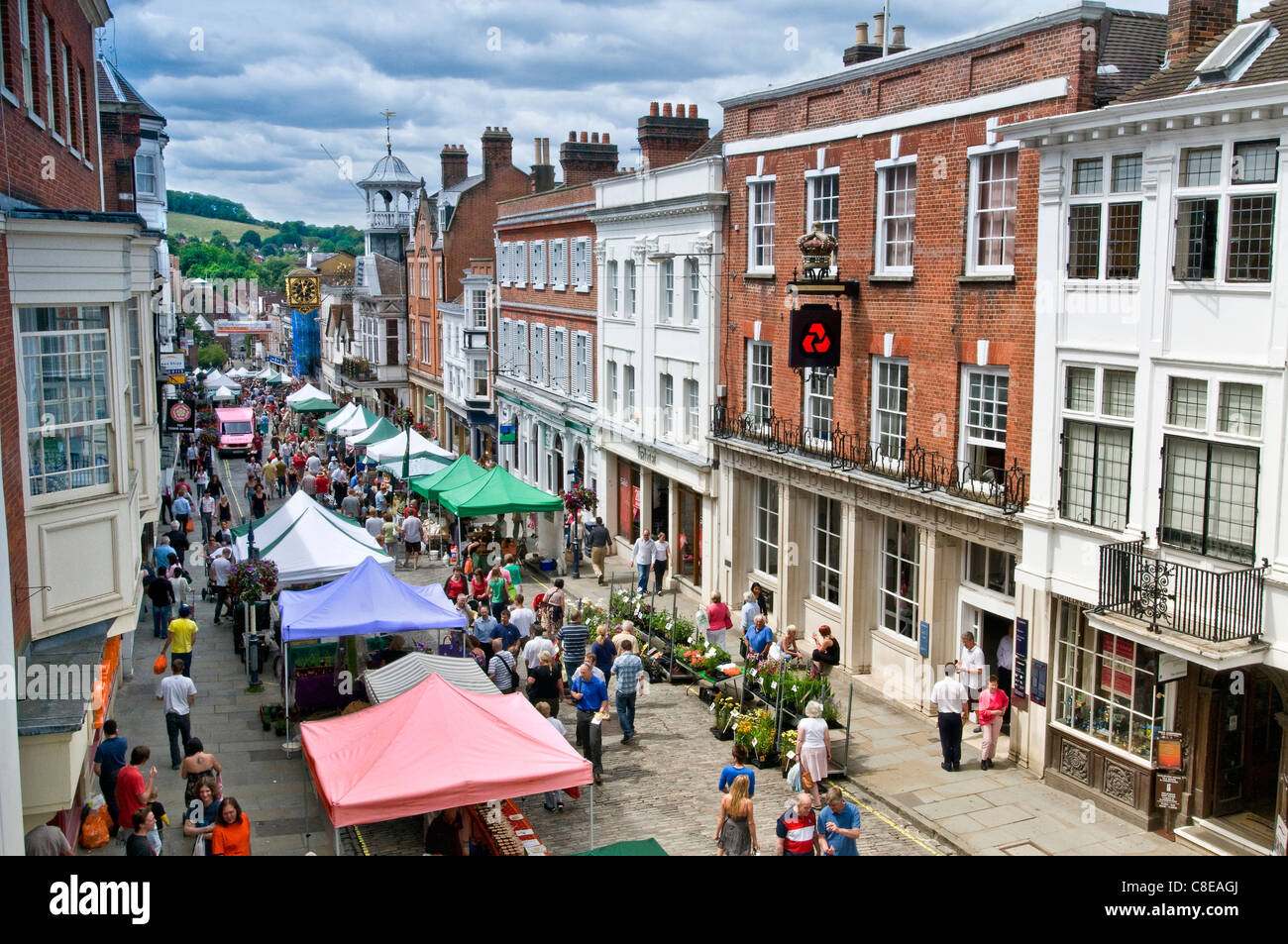 Alfresco food & artisan stalls Guildford high street market in historic high street with shoppers on a busy summer market day Guildford Surrey UK Stock Photo