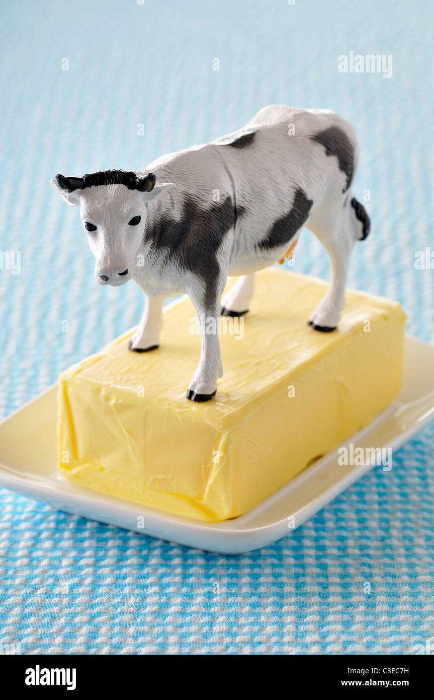 Platic cow on a slab of butter Stock Photo
