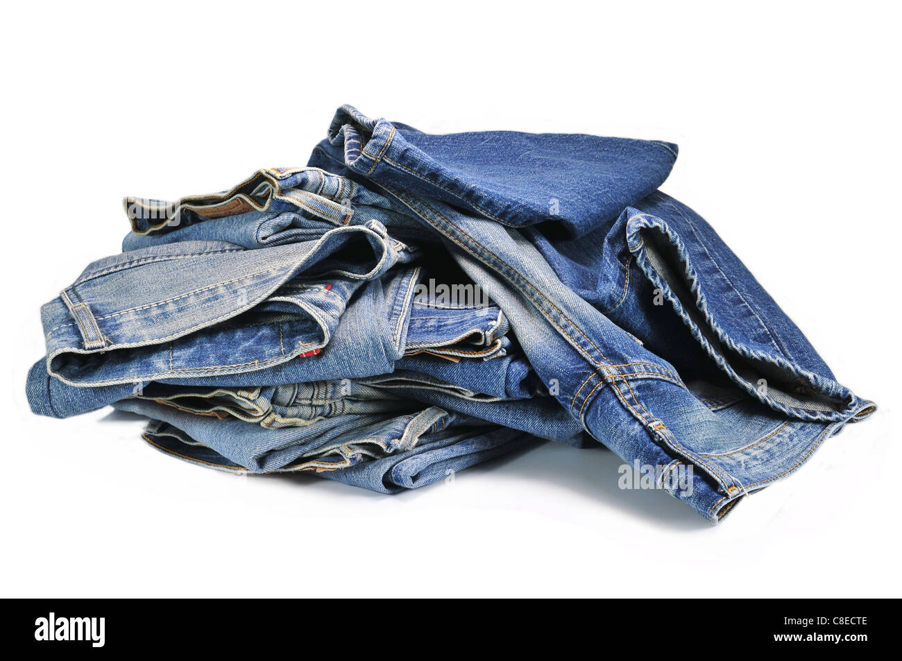 Pile of blue denim jeans isolated on white background Stock Photo - Alamy