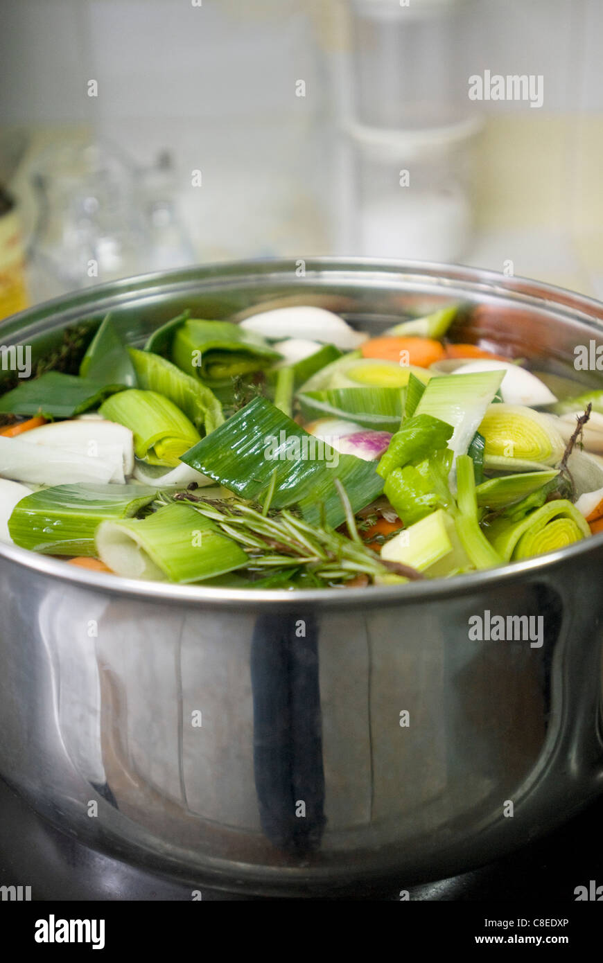 Cooking the pig's trotters in a court-bouillon with the vegetables Stock Photo