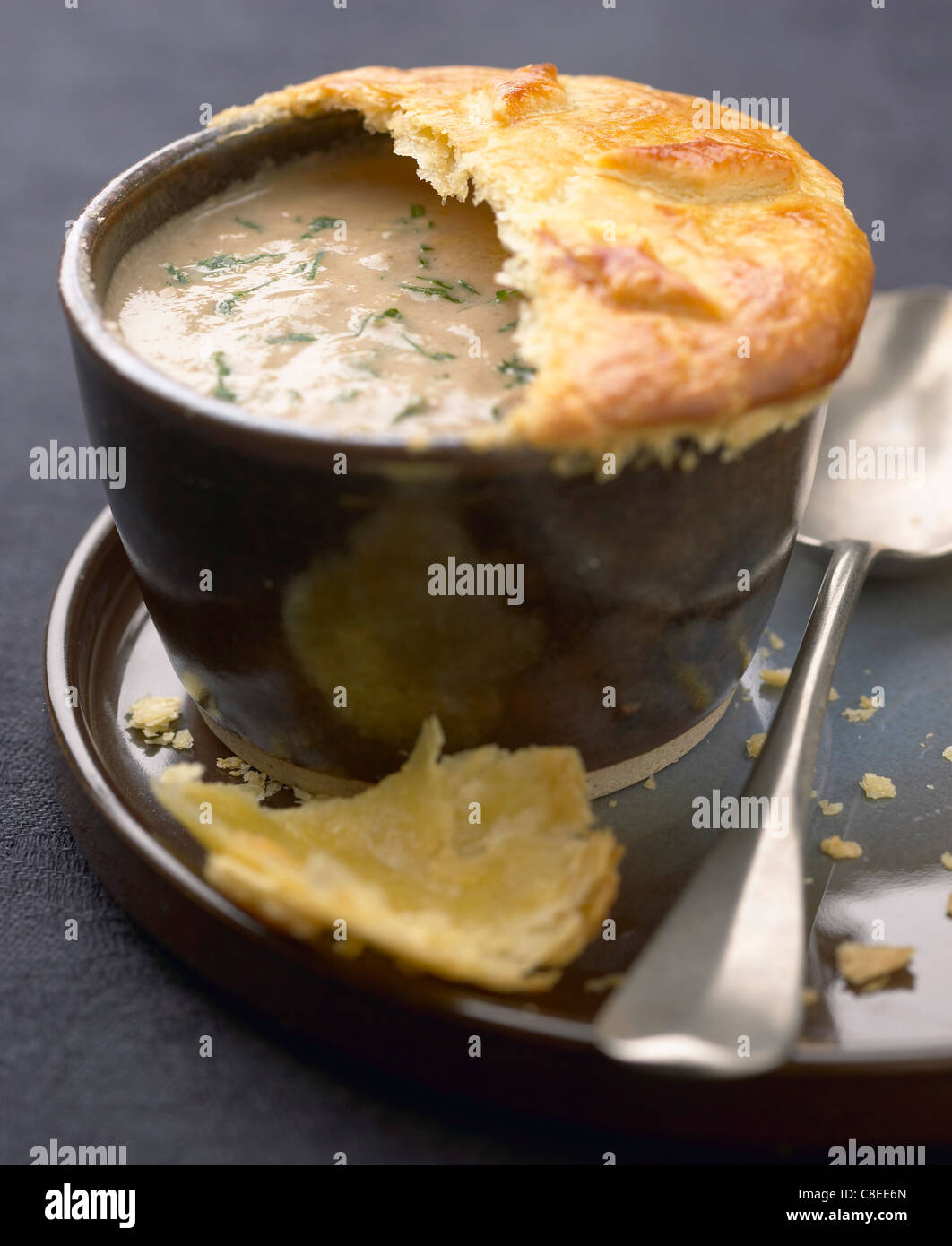 Cream of mushroom soup sealed with flaky pastry Stock Photo