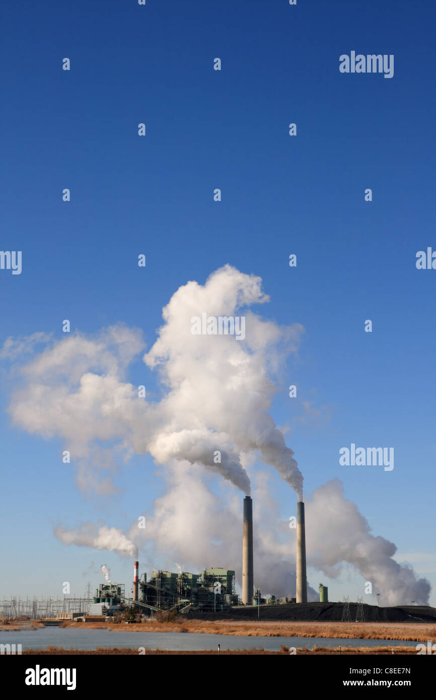 vertical image of Cholla coal fired electric power plant in Arizona with white steam clouds and blue sky copy space Stock Photo