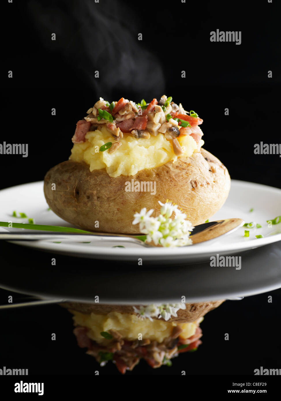 Baked potato with diced bacon and mushrooms Stock Photo