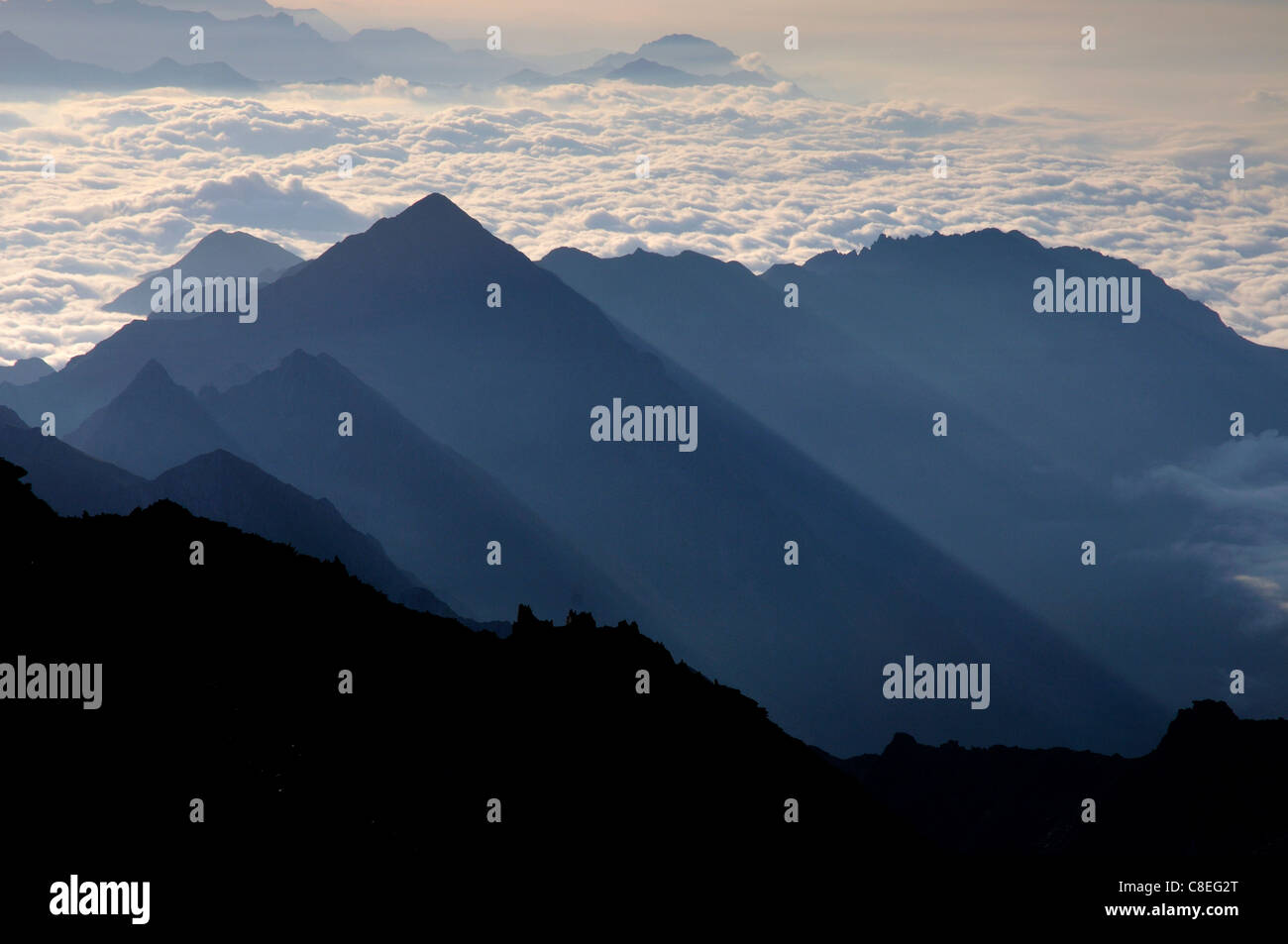 Clouds fill the valleys of Italy as seen from high on Weissmies in the Swiss Alps Stock Photo