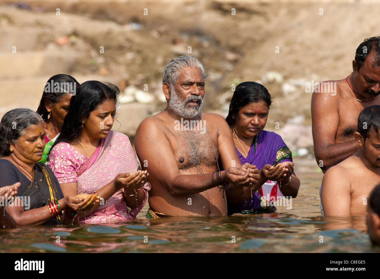 Indian Hindu men and women bathing and praying in the River Ganges by Kshameshwar Ghat in holy city of Varanasi, India Stock Photo