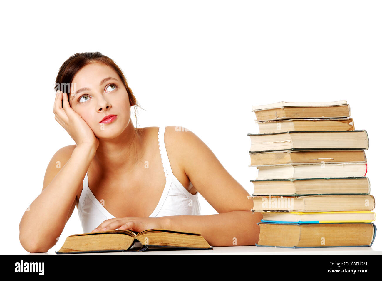 Young student girl sitting with book near the pile of books and ...